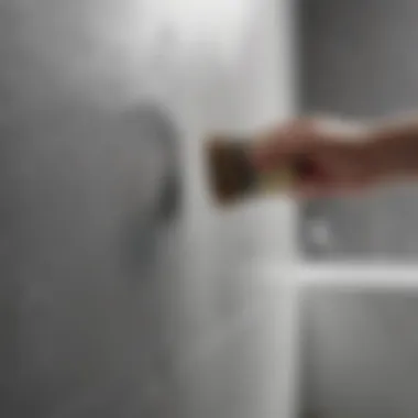 A close-up of a brush applying waterproof paint to bathroom walls, illustrating an effective application technique.