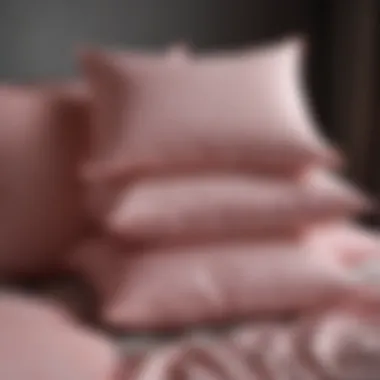 A collection of various textured pink pillows on a neutral backdrop.